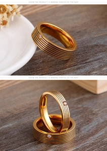 Detailed close-up of golden striped titanium ring with a single centered zircon stone
