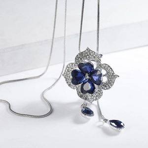 Elegant floral necklace with blue sapphire crystals and silver clover frame on white stone