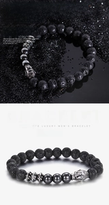 Macro shot of lava stone bead bracelet featuring a detailed silver buddha head charm