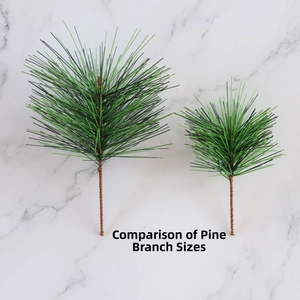 Size comparison of two artificial pine branches for Christmas DIY decor on marble background