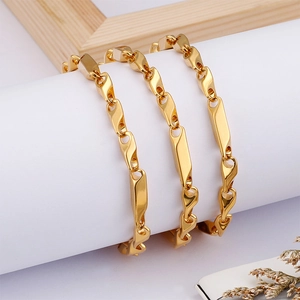 Polished gold stainless steel rhombus chain necklace wrapped around a minimalist stand