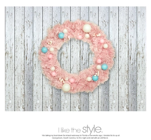 Detail of pink Christmas macaron wreath with blue balls on white wooden background