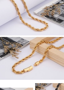 Detail shot of golden twisted rope chain necklace with cylindrical clasp on a white background