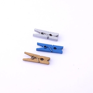 Macro shot of 2.5cm colorful wooden clips in silver, blue and gold with metal springs