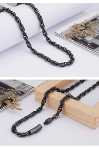 Detail view of gold stainless steel chain necklace and textured lobster clasp closure
