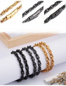 Macro detail of gold and black thick chain necklaces with cylinder clasp closure