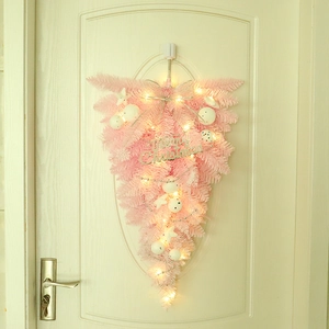 Pink Christmas upside-down tree swag with LED lights and Merry Christmas sign on white door