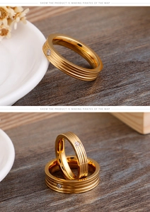 Close-up of gold-plated titanium ring with parallel grooves and a sparkling zircon stone