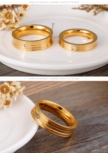 Macro shot of gold-plated couple rings with parallel grooves and centered sparkling zircon