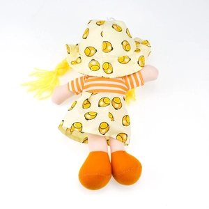 Close-up of cute plush doll featuring yellow yarn braids and orange fruit print hat