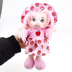 Detail of pink rag doll with braided hair, blue eyes, and fruit print dress for girls