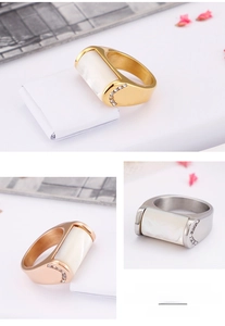 Close-up of minimalist shell rings in gold, silver, and rose gold with zircon details