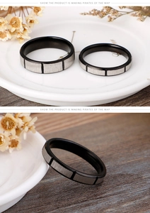 Detail of black and silver brushed stainless steel ring with square block design