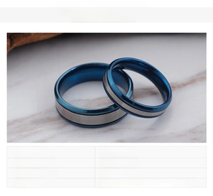 Detail view of blue and silver stainless steel couple rings with brushed metal texture