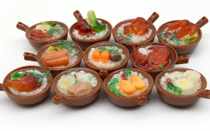 Detailed macro view of assorted mini PVC food models with realistic clay pot rice and noodles