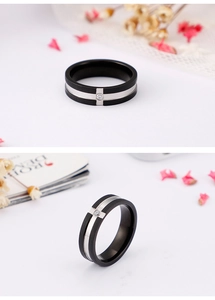 Detail of a black brushed steel ring with a polished silver groove and a center zircon