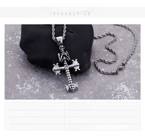 Macro shot of stainless steel skull cross pendant featuring a small central sparkling diamond