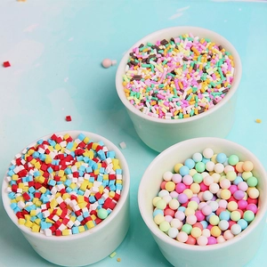 Gros plan de vermicelles colorés en pâte polymère dans des bols blancs pour décoration DIY