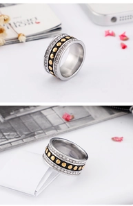 Detailed macro view of wide band ring featuring black center strip with gold studs and zircons