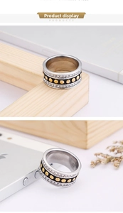 Detail of wide stainless steel ring with double-row zircon pavé and gold studs