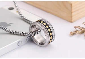 Macro view of stainless steel ring pendant with zircon inlay and golden dot pattern