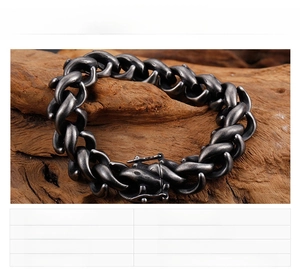 Detail of heavy vintage black stainless steel chain bracelet on natural wood background