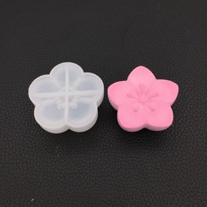 Detail of 3D cherry blossom silicone mold with a finished pink resin flower craft