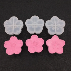 Detail view of cherry blossom silicone molds and finished pink gypsum flower crafts
