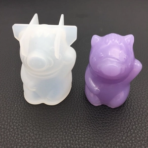 Detail of 3D pig silicone mold next to a purple resin craft on black leather background