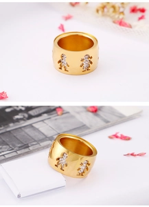 Close-up of gold titanium steel wide band ring featuring hollow boy and girl motifs