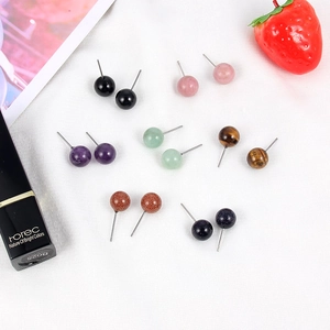 Flat lay of seven pairs of 10mm round gemstone stud earrings in diverse natural colors