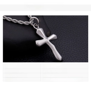 Detailed view of a stainless steel cross pendant on a rope chain over textured background