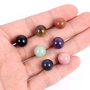 Close-up of seven natural 10mm stone beads held in hand showing polished texture