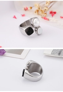 Macro view of silver titanium steel ring with pearl, black glitter and white stones