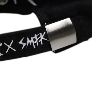 Détail de la sangle noire réglable avec logo SMFK blanc et boucle en métal argenté