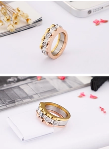 Detailed view of tricolor stacked stainless steel ring with gear edges and white zircons