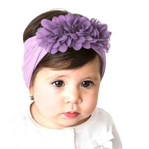 Detailed view of baby purple nylon headband with three soft chiffon flowers on a model