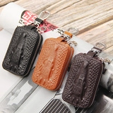 Macro detail of alligator pattern leather key wallets in black, orange, and brown colors