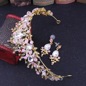 Detail of luxury bridal crown and earrings set with pink rhinestones on gold base