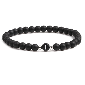 Detail of 6mm matte black stone bead bracelet with letter I and silver metal accents