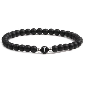 Close-up of matte black bead bracelet with letter T charm and silver spacers