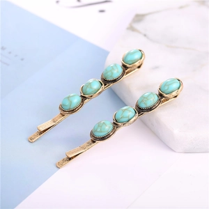 Close-up of vintage bronze hair clips set with turquoise oval stones on elegant background