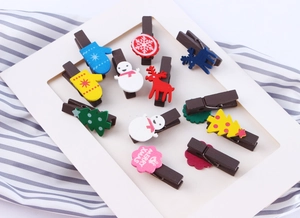Close-up of decorative Christmas wooden clips featuring reindeer and snowflake designs