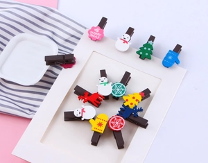 Close-up of assorted Christmas wooden clips featuring snowmen and reindeer on a card