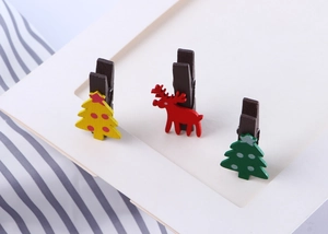 Detail of festive wooden clips featuring colorful Christmas trees and a red reindeer design