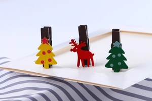 Close-up of wooden Christmas photo clips featuring reindeer and Christmas tree designs