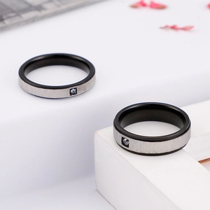 Minimalist black and silver titanium steel rings with single zircon on white steps