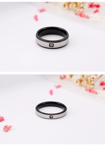 Detail of matte black and brushed silver titanium ring with a small square diamond