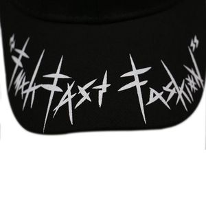 Macro shot of white Fast Fashion embroidery on a black cotton baseball cap brim