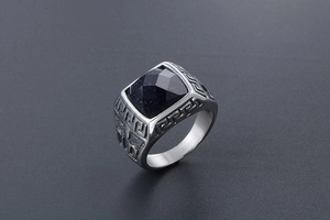Close-up of silver steel ring with blue sandstone and vintage Greek key patterns